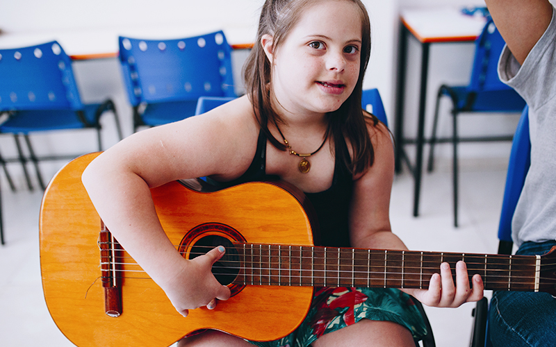 Fotografia de aluna Alicerce tocando violão