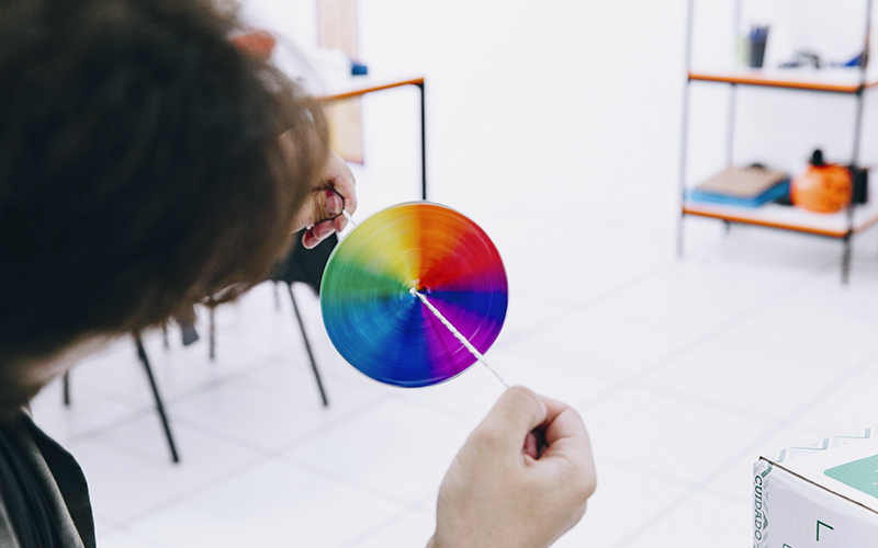 Fotografia de uma criança brincando com uma atividade com um circulo colorido 