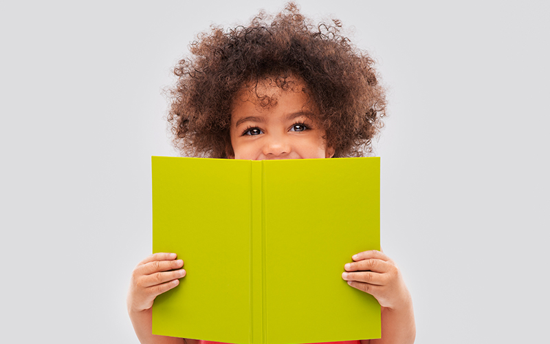 Fotografia de uma criança lendo um livro